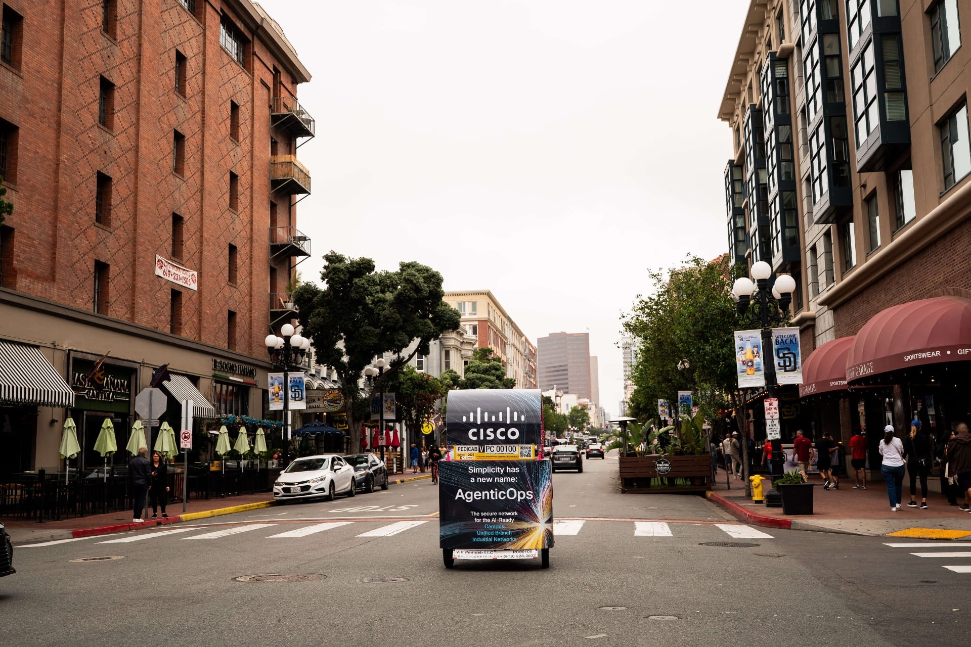 Cisco AgenticOps pedicab rear view riding through Gaslamp Quarter street
