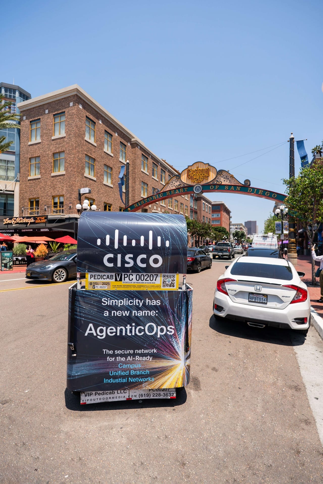 Cisco AgenticOps pedicab wrap closeup with Gaslamp Quarter archway background