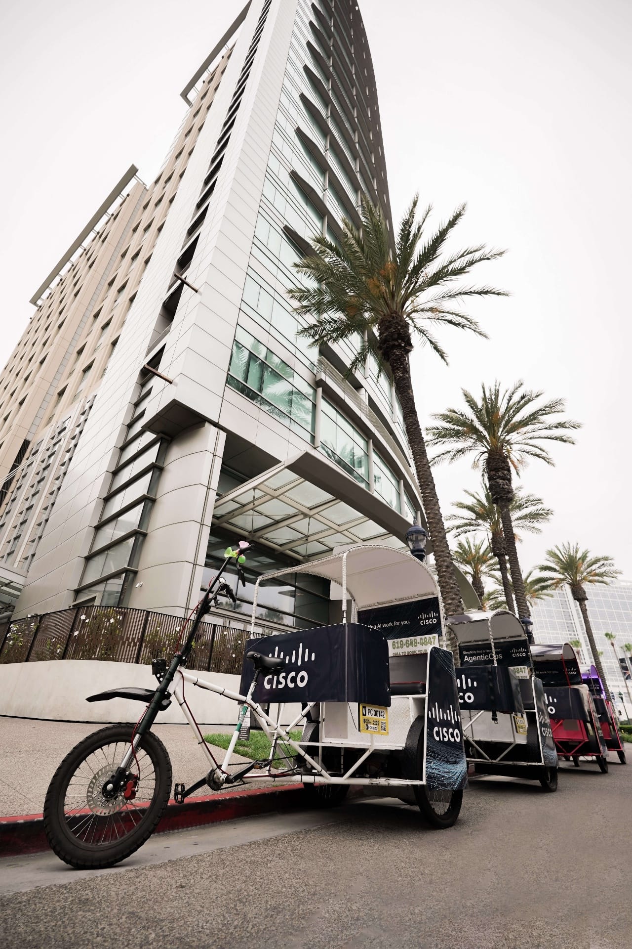 Cisco branded pedicab fleet among palm trees downtown San Diego