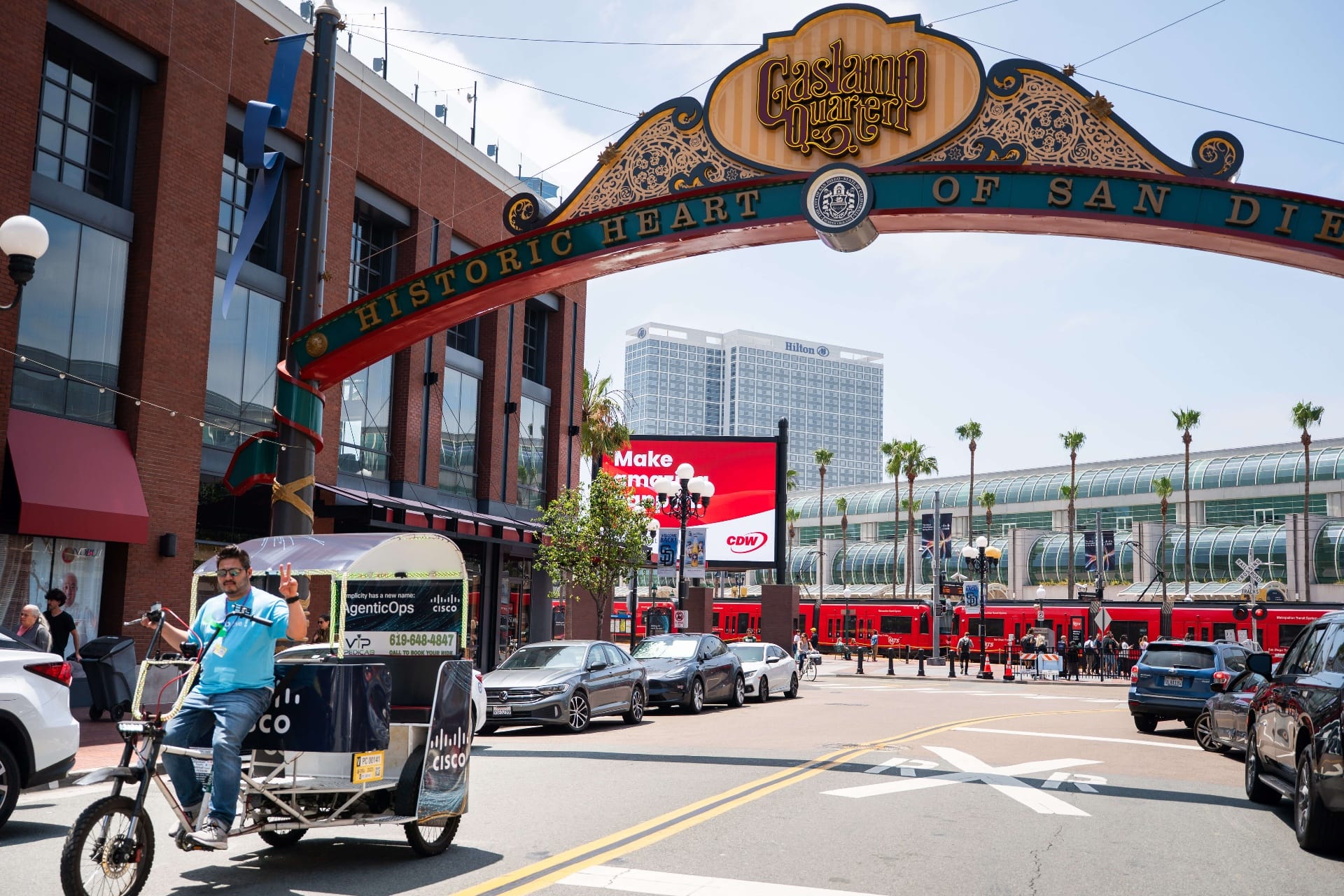 Cisco pedicab fleet riding under historic Gaslamp Quarter archway sign