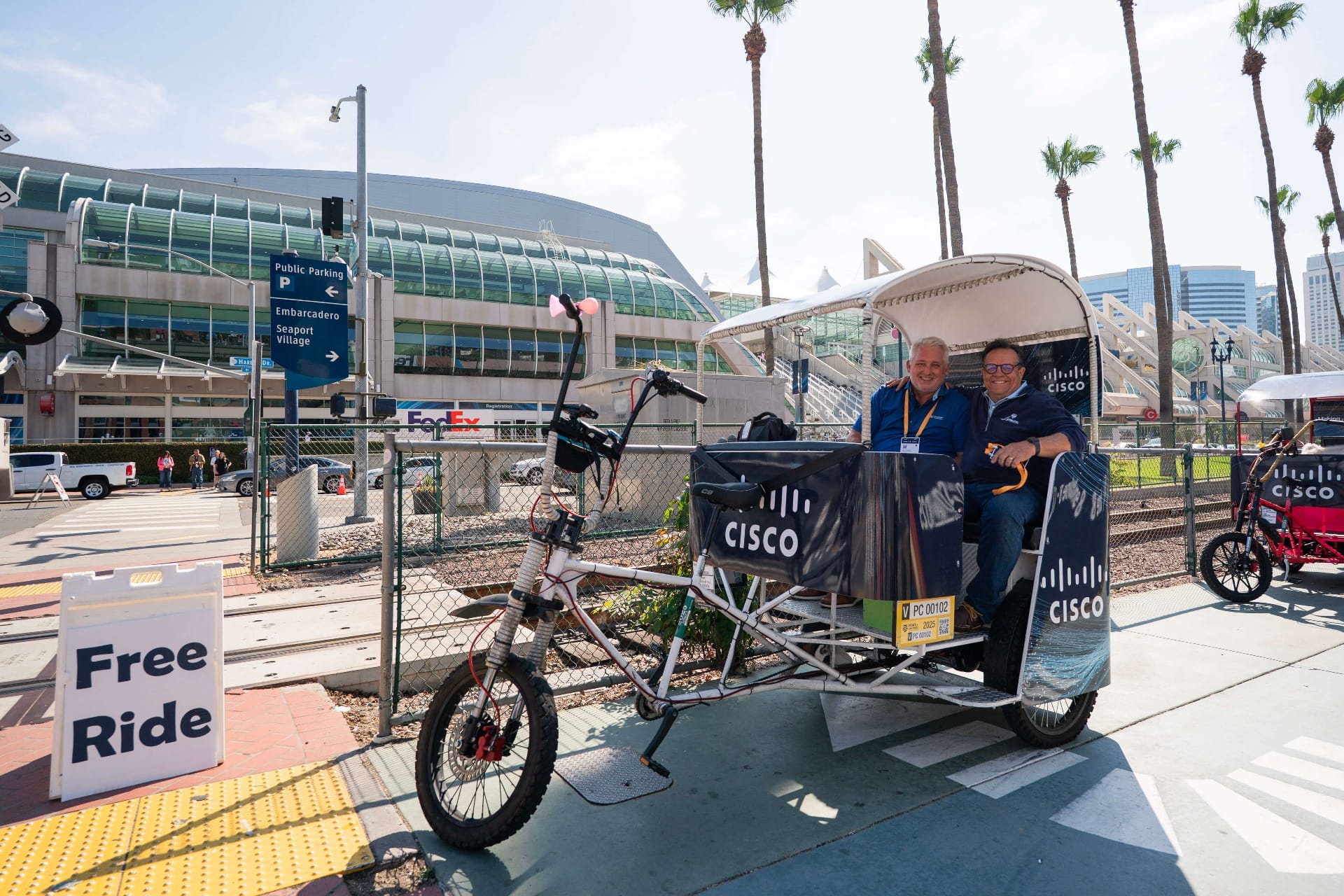 Happy Cisco executives riding branded pedicab at San Diego Convention Center