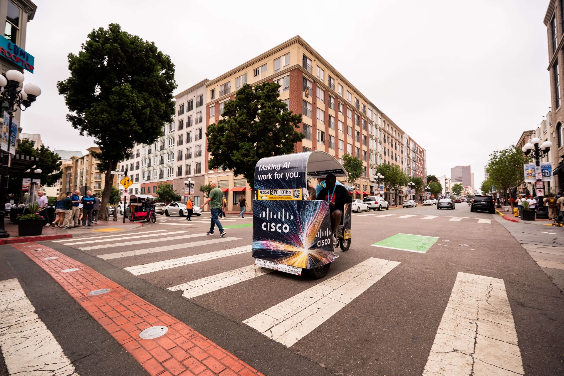 Cisco Making AI Work branded pedicab cruising through downtown intersection