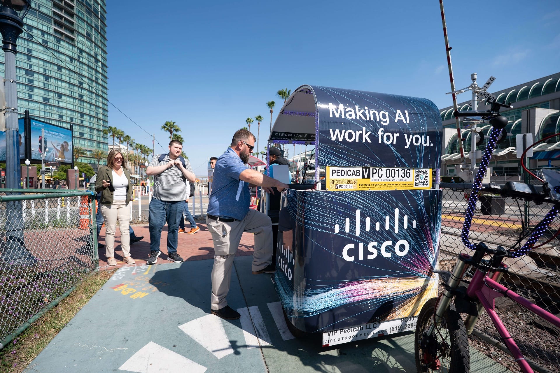 Attendees boarding Cisco branded pedicab outside Convention Center