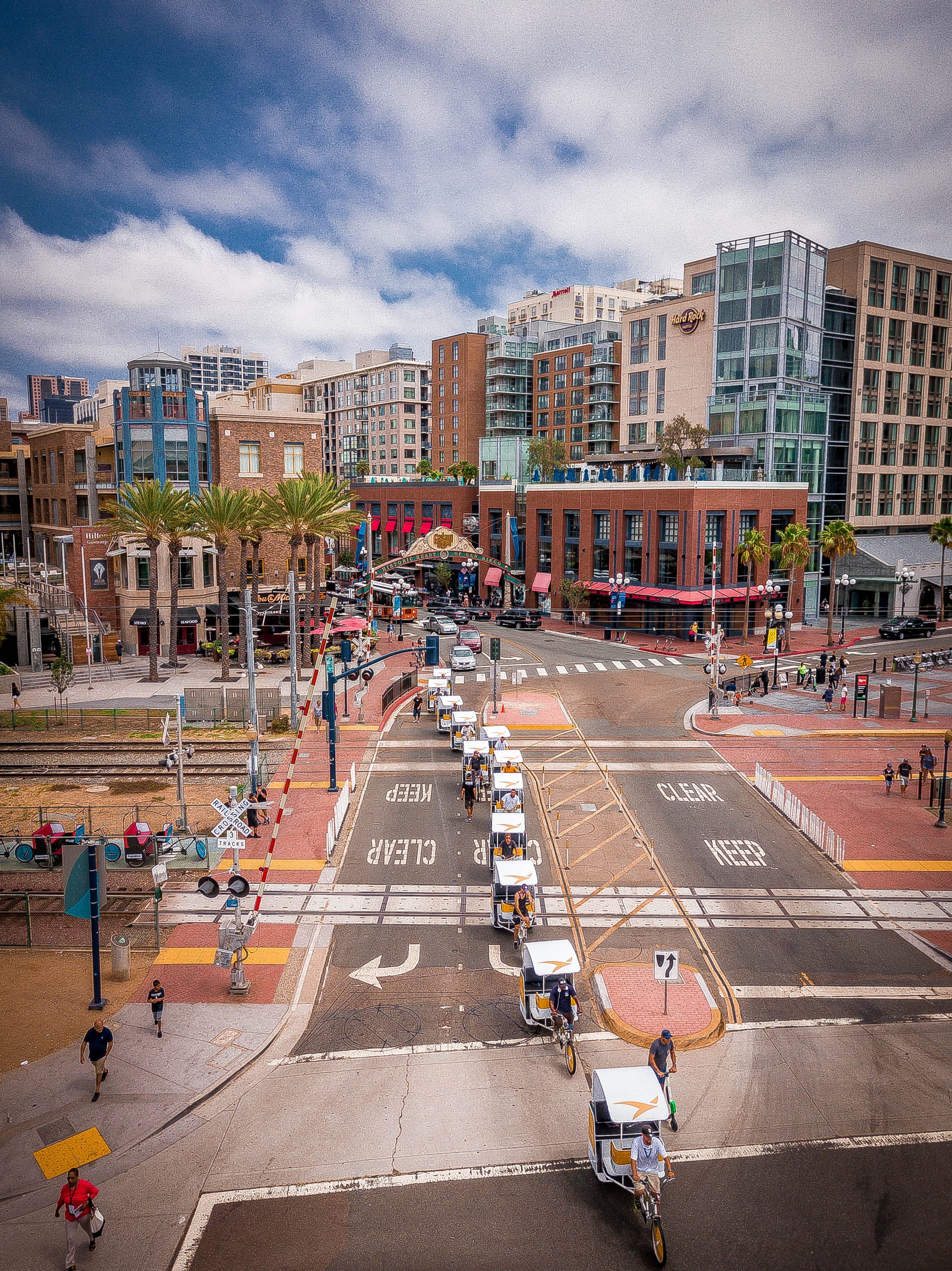 Branded pedicab fleet crossing the Gaslamp Quarter trolley tracks in San Diego