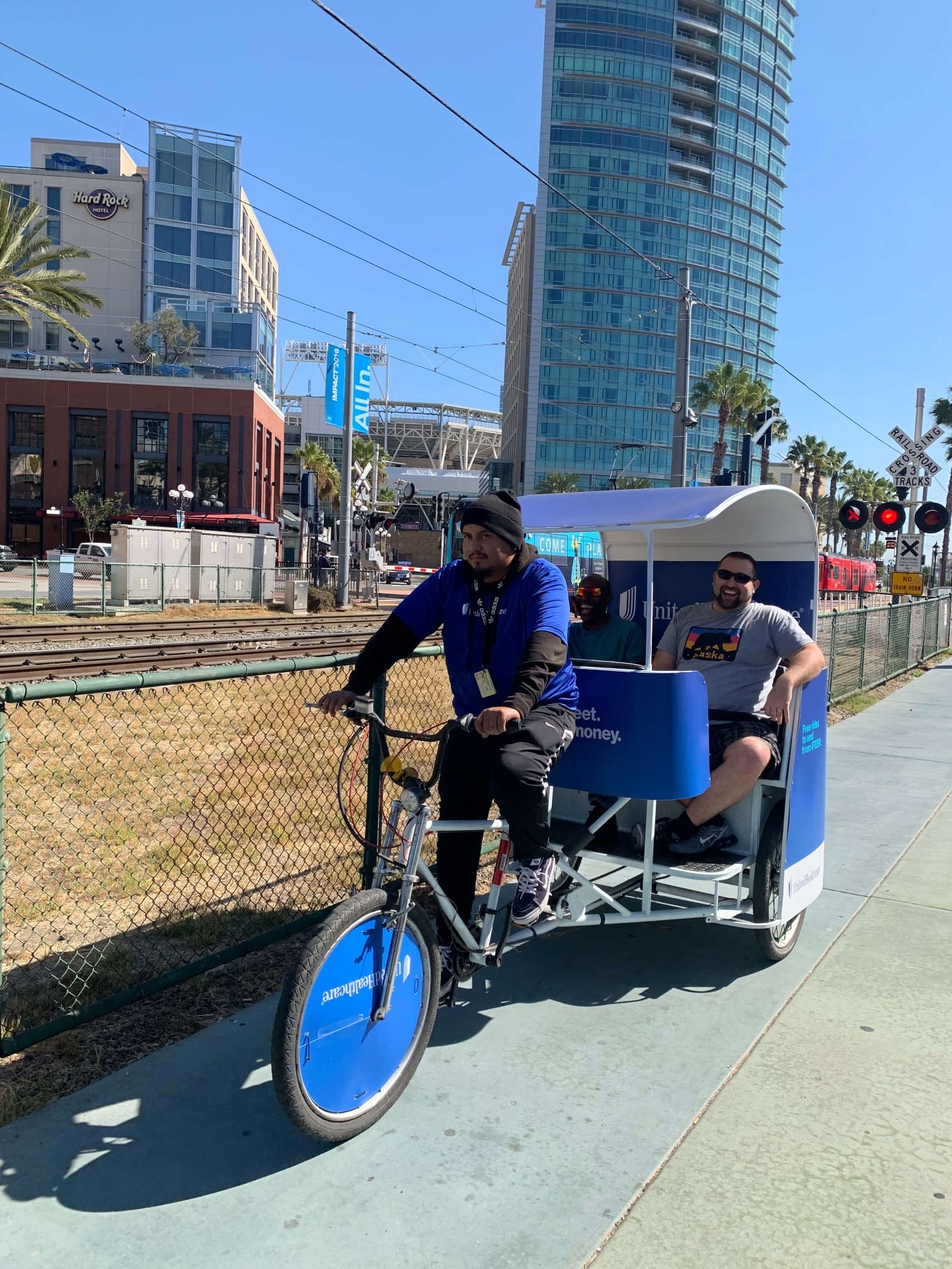 Pedicab passengers riding through downtown San Diego near Hard Rock