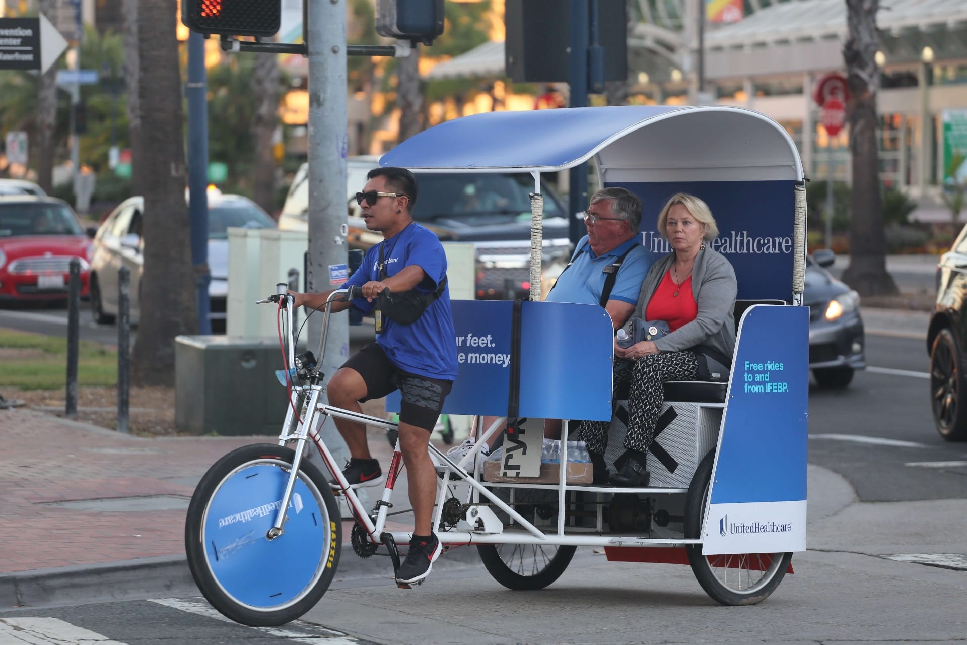Couple riding UnitedHealthcare branded pedicab near Convention Center