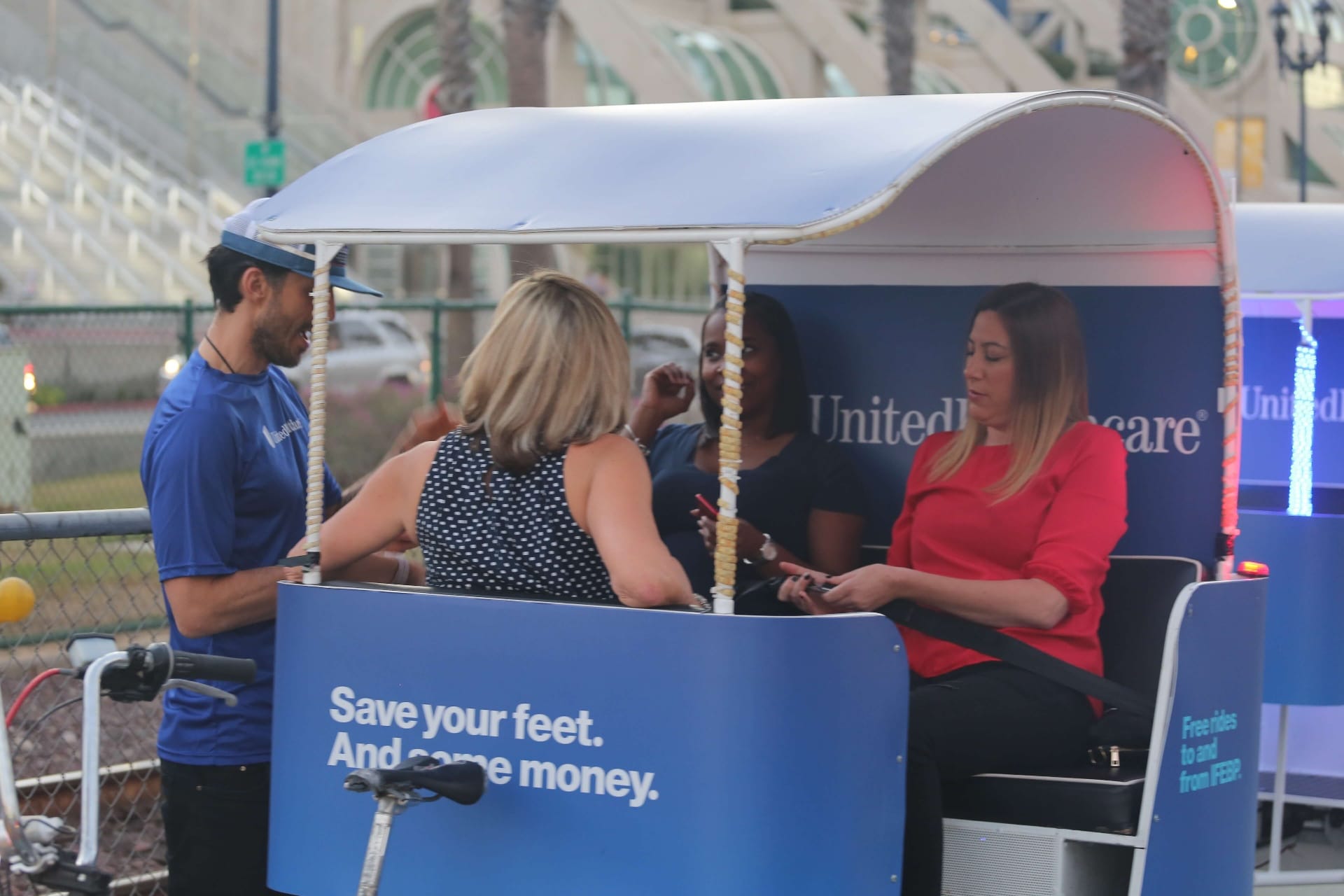 UnitedHealthcare pedicab passengers boarding for evening IFEBP event ride