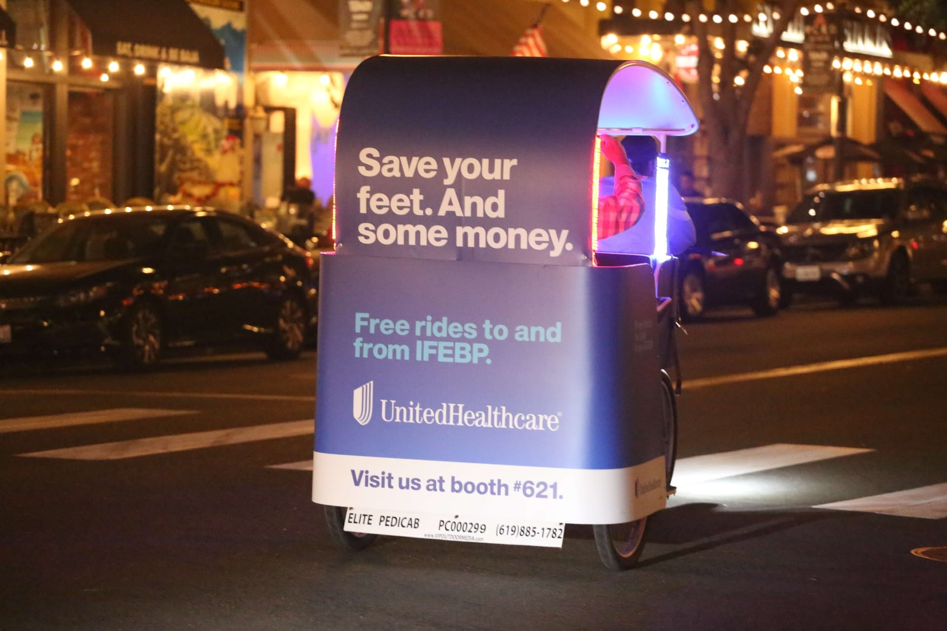 UnitedHealthcare pedicab wrap closeup at night showing brand advertising